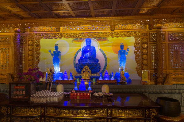 Blau leuchtende Buddha-Statuen in einem Tempel